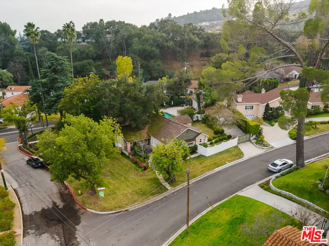 an aerial view of house with yard and mountain view in back