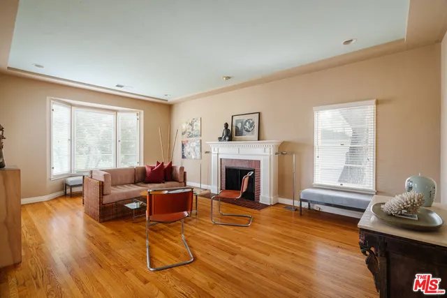 a living room with furniture a fireplace and wooden floor