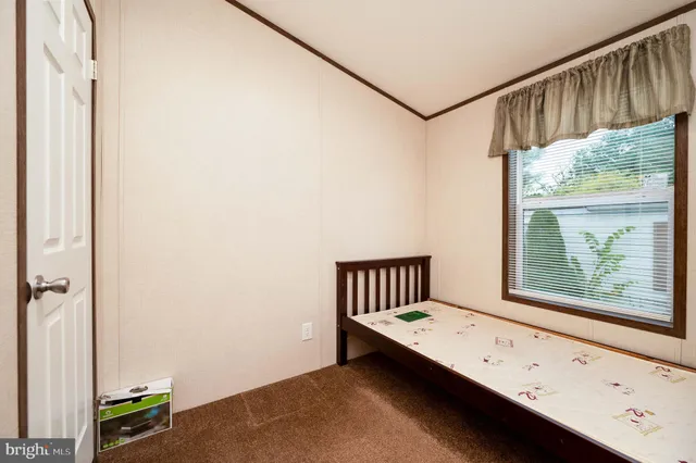 a view of hallway with window and wooden floor