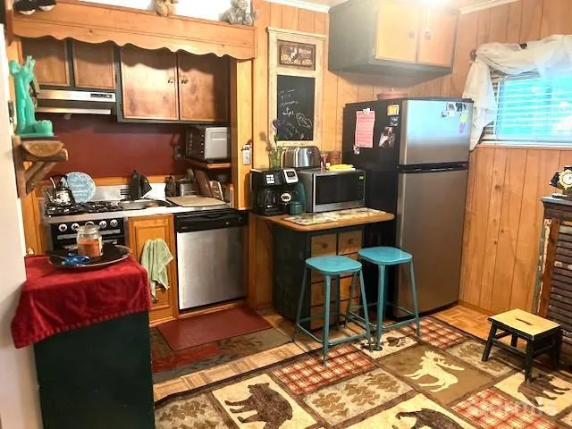 a kitchen with stainless steel appliances granite countertop a refrigerator and a stove