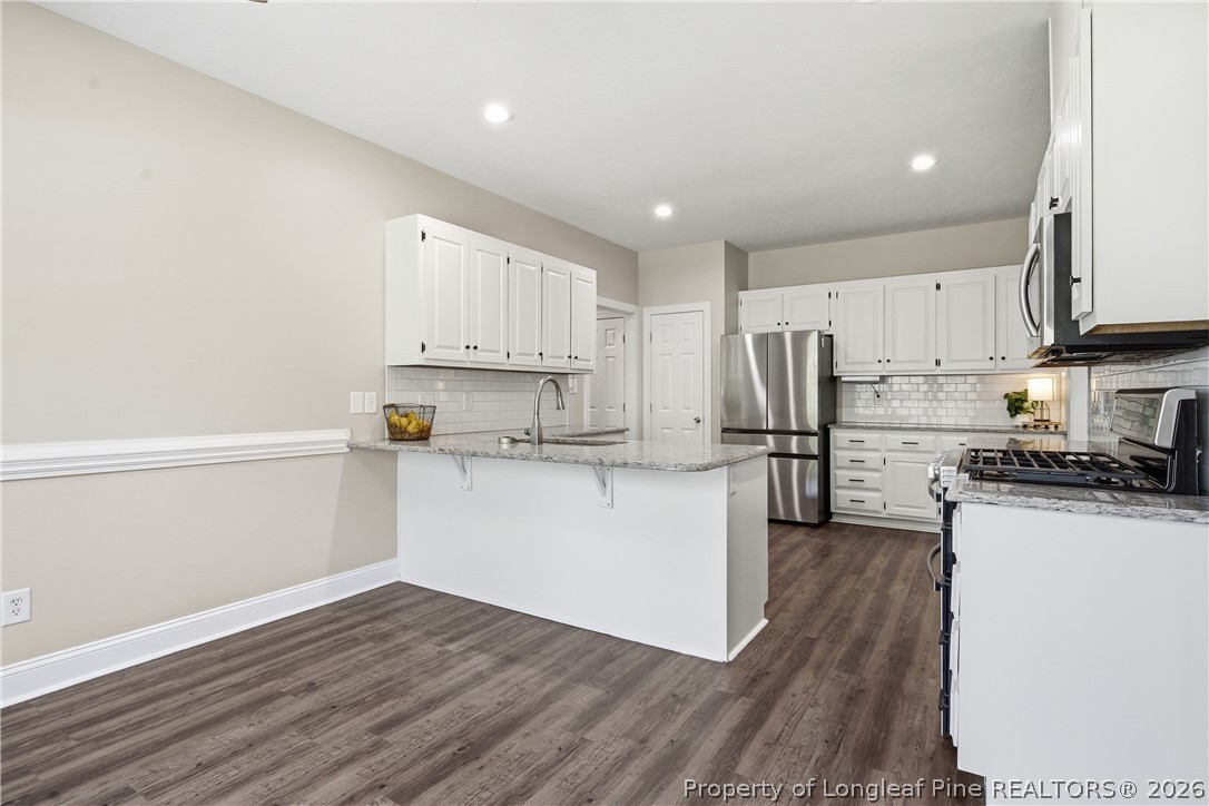 152 Ham Road Hope Mills, NC 28348 - Photo 14 of 50 a kitchen with stainless steel appliances a refrigerator sink and white cabinets