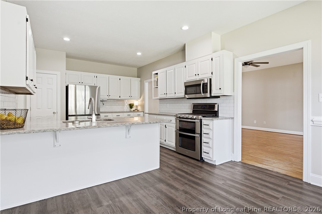 152 Ham Road Hope Mills, NC 28348 - Photo 15 of 50 a kitchen with stainless steel appliances a stove top oven a sink a refrigerator a microwave and cabinets