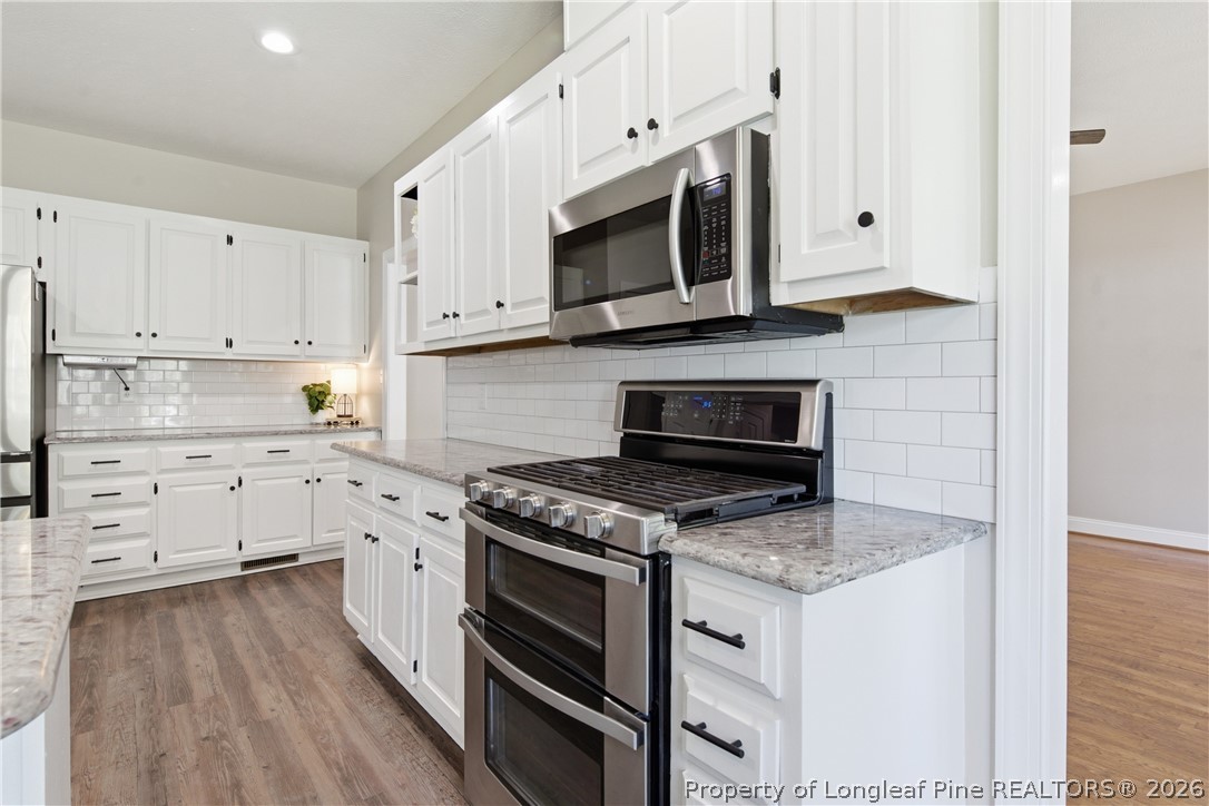 152 Ham Road Hope Mills, NC 28348 - Photo 16 of 50 a kitchen with stainless steel appliances granite countertop a stove microwave and cabinets