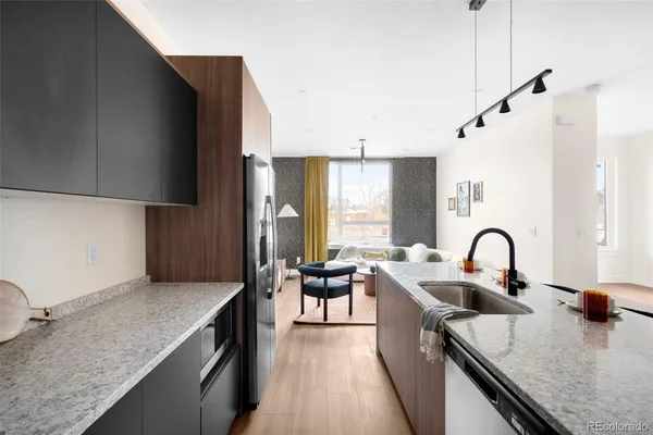 a kitchen with granite countertop a sink a counter space appliances and cabinets