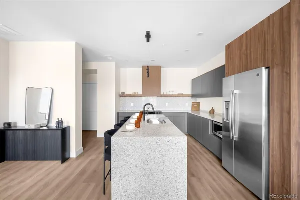 a kitchen with granite countertop a refrigerator a sink dishwasher with a dining table and chairs