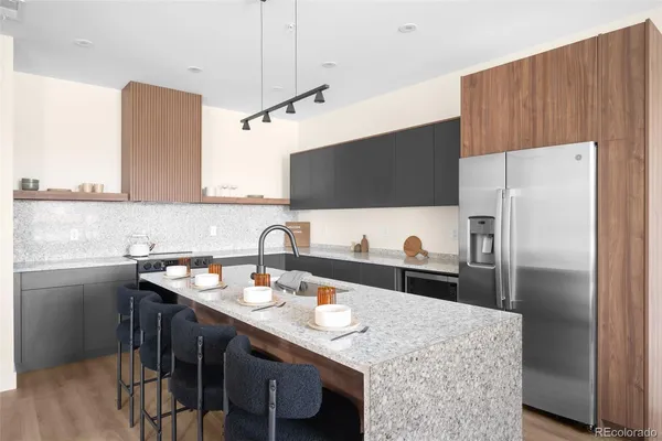 a kitchen with stainless steel appliances granite countertop a sink refrigerator and microwave