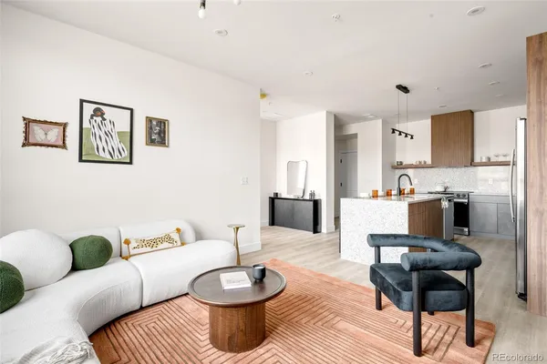 a living room with furniture and a view of kitchen