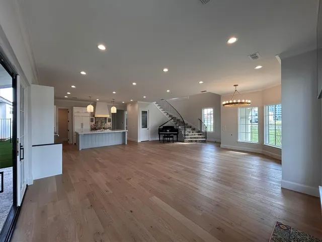 a large white kitchen with kitchen island white cabinets and stainless steel appliances