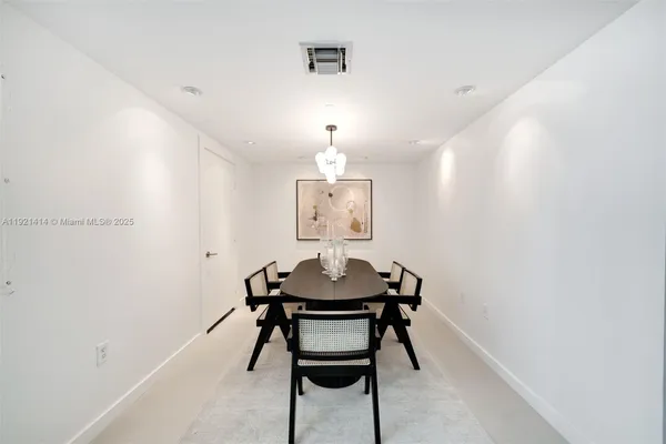 a view of a room with a table and chairs