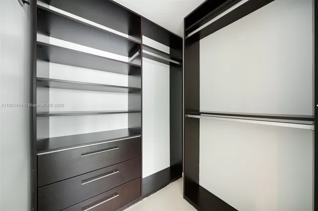 a view of walk in closet with empty racks