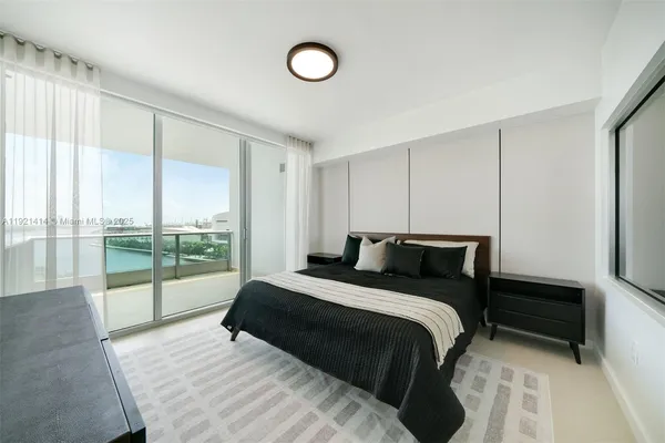 a bedroom with a bed and a large window
