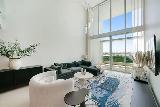 a living room with furniture and a floor to ceiling window