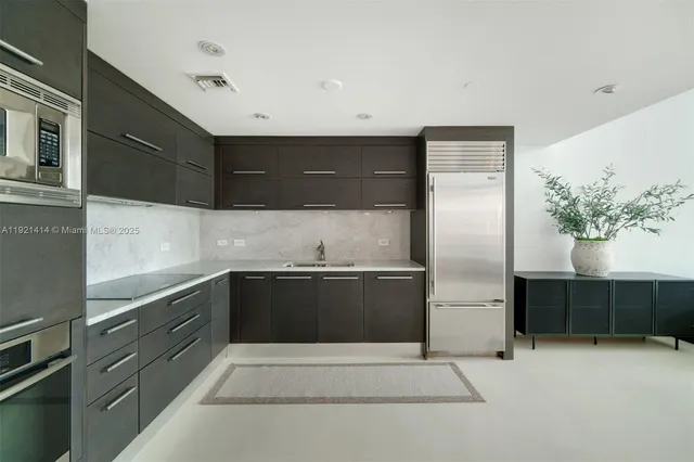 a kitchen with stainless steel appliances granite countertop a refrigerator and a sink