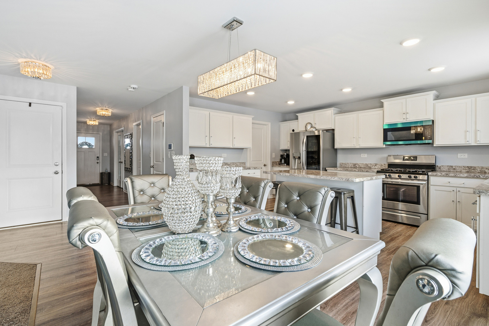 434 Stonebrook Drive Romeoville, IL 60446 - Photo 12 of 38 a kitchen with stainless steel appliances kitchen island granite countertop a sink a stove a kitchen island with chairs and white cabinets