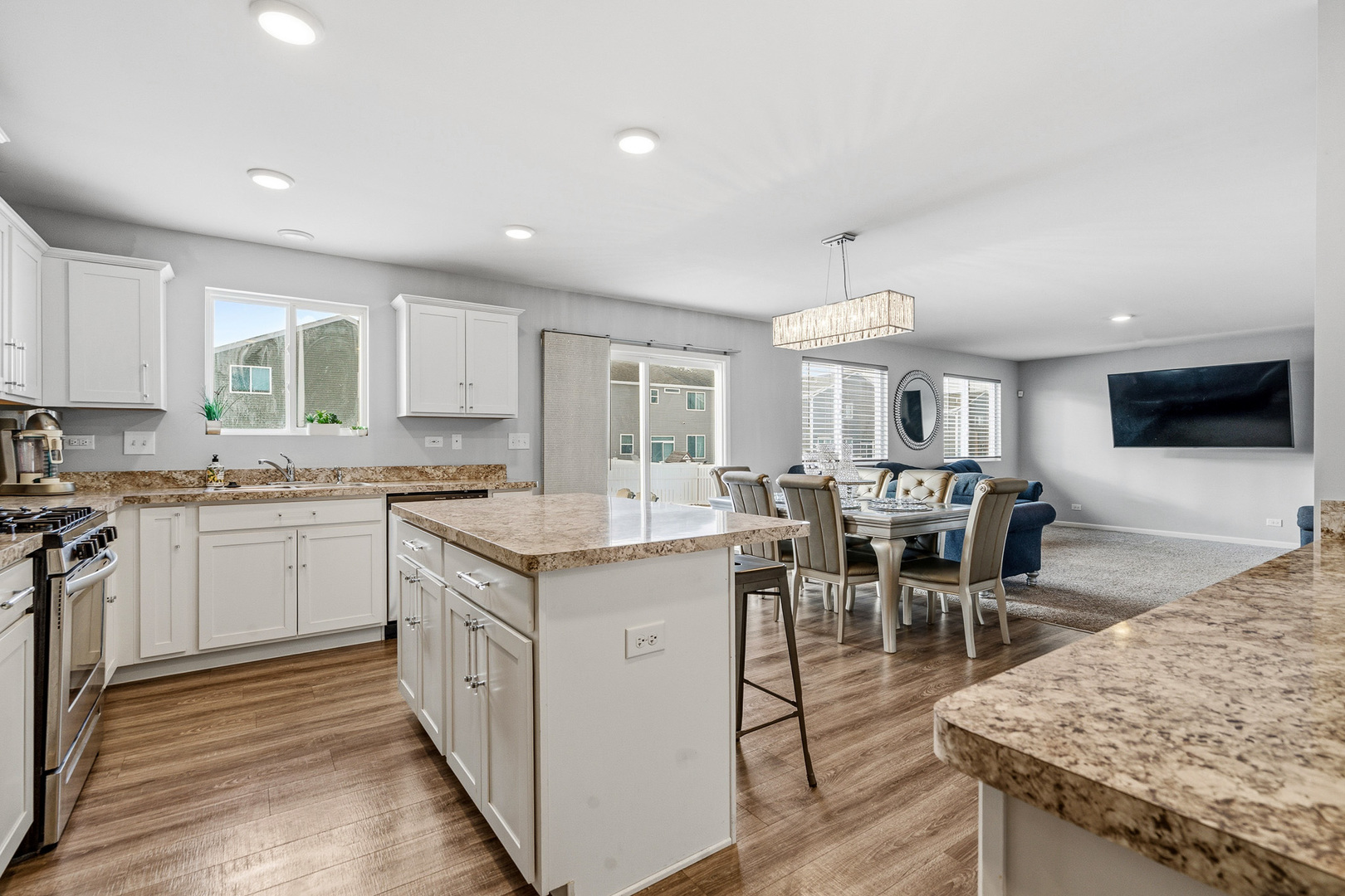 434 Stonebrook Drive Romeoville, IL 60446 - Photo 9 of 38 a kitchen with granite countertop sink stove and white cabinets