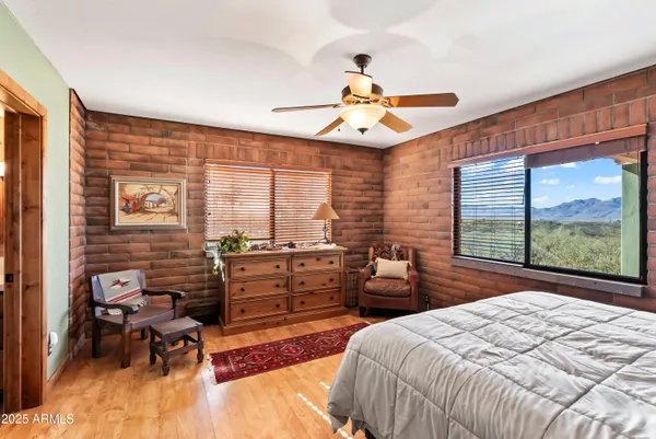 a bedroom with a bed and large windows