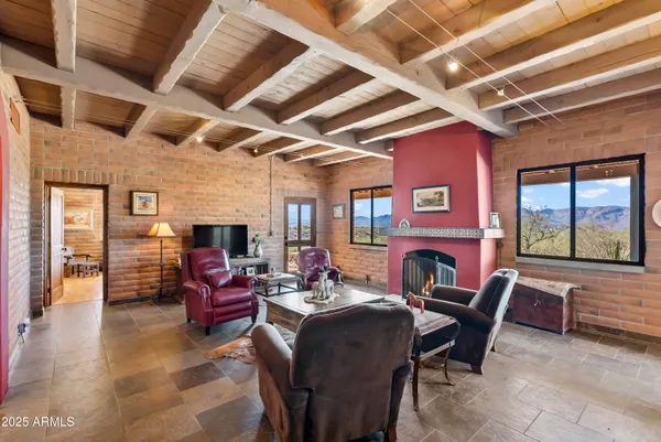 a view of a dining room with furniture a fireplace and wooden floor
