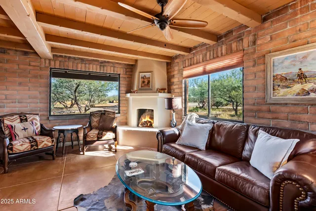 a living room with fireplace furniture and a large window