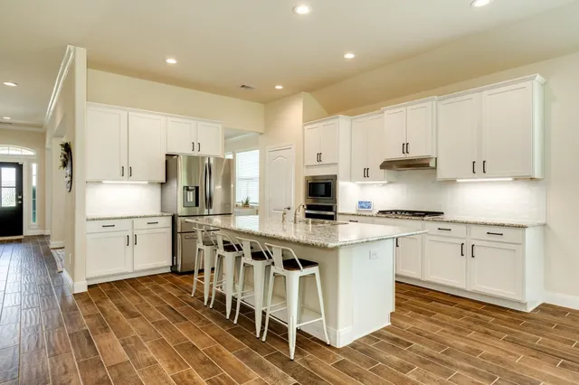 a kitchen with white cabinets stainless steel appliances and sink