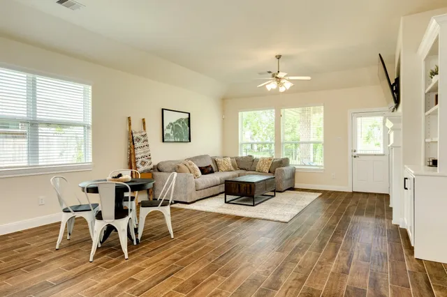 a living room with furniture windows and a wooden floor