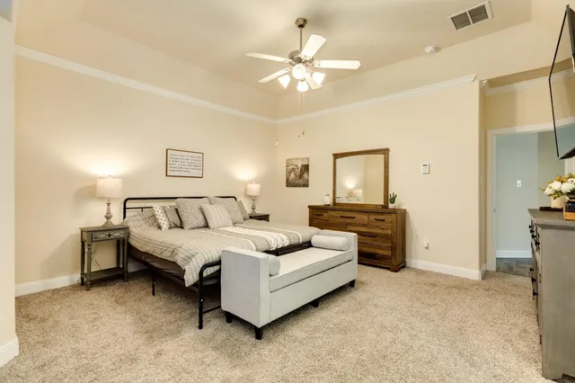 a spacious bedroom with a bed and a chandelier