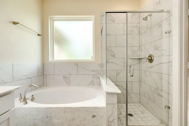 a white bath tub sitting next to a shower