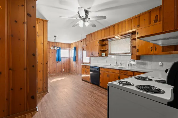 a kitchen view with wooden cabinets and white appliances