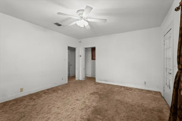 an empty room with a ceiling fan and a window