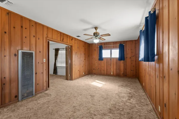an empty room with windows and cabinet