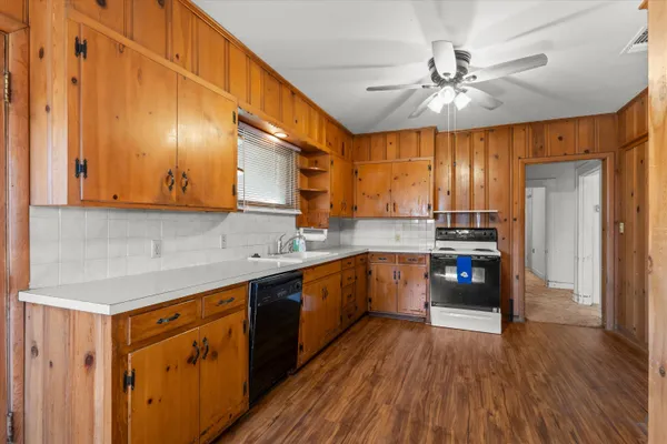 a kitchen with stainless steel appliances a sink cabinets and wooden floor