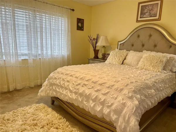 a large bed sitting in a bedroom next to a window