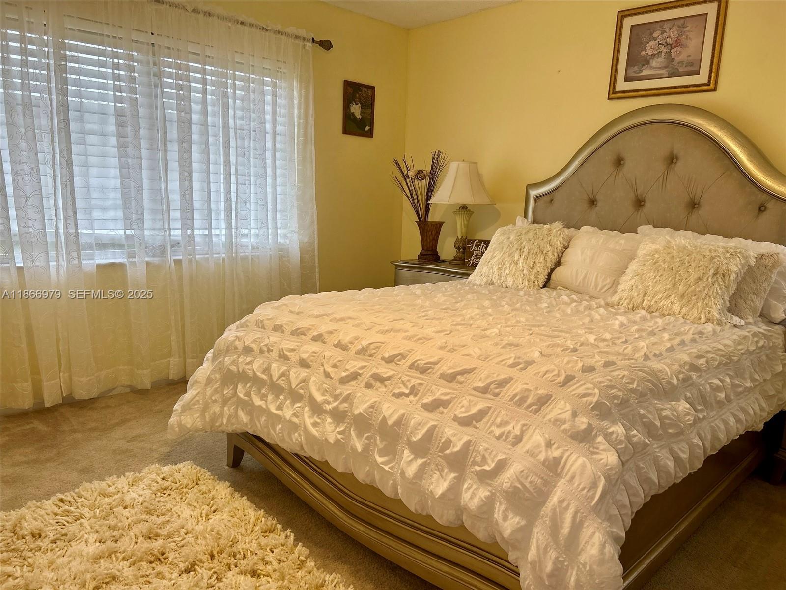 9802 Marina Boulevard, Unit 125 Boca Raton, FL 33428 - Photo 18 of 33 a large bed sitting in a bedroom next to a window