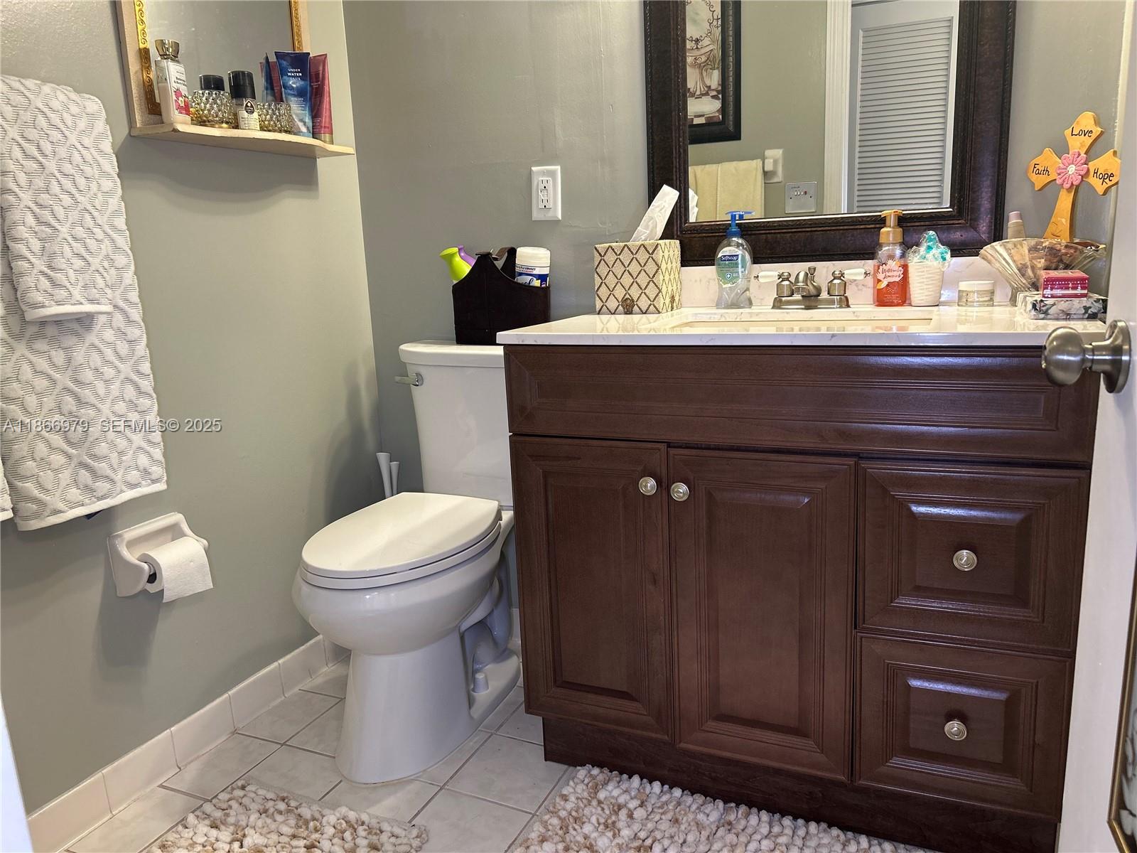 9802 Marina Boulevard, Unit 125 Boca Raton, FL 33428 - Photo 23 of 33 a bathroom with a sink a toilet and a mirror