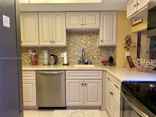a kitchen with white cabinets and sink