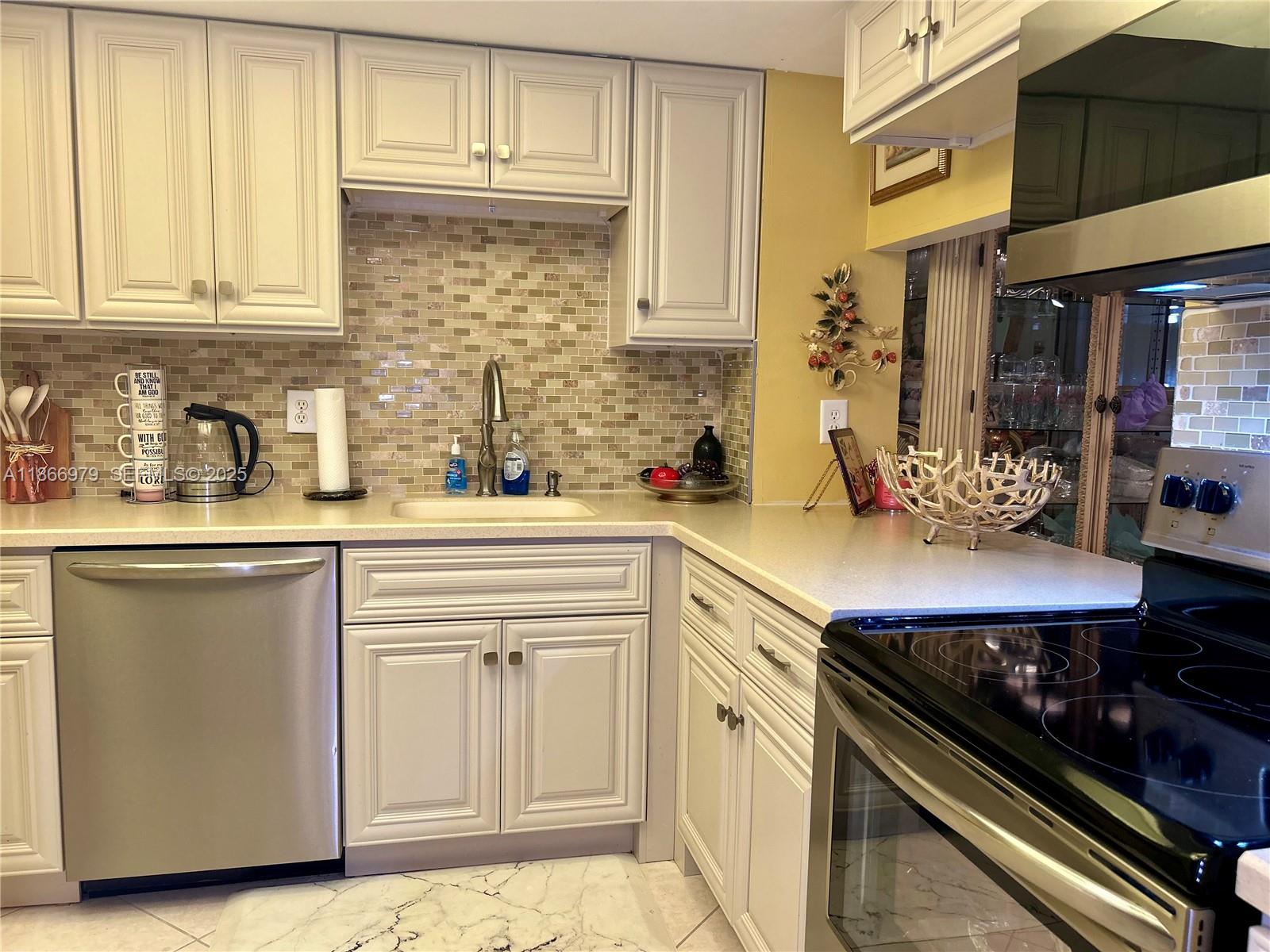 9802 Marina Boulevard, Unit 125 Boca Raton, FL 33428 - Photo 27 of 33 a kitchen with stainless steel appliances granite countertop a sink stove and cabinets