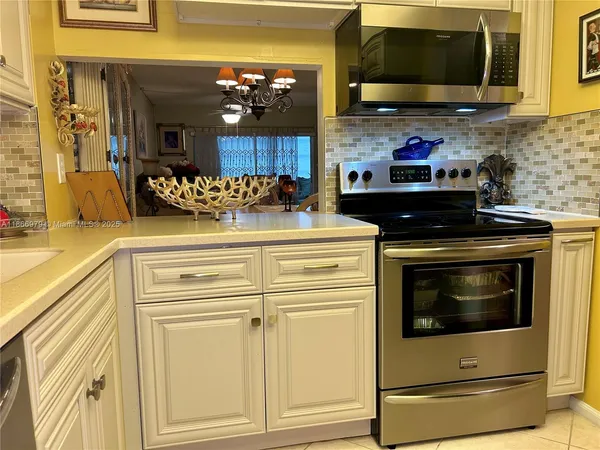 a kitchen with stainless steel appliances granite countertop a stove and a microwave