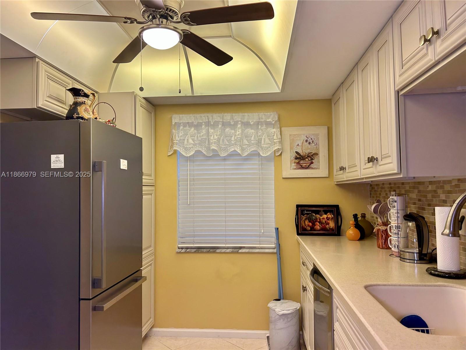 9802 Marina Boulevard, Unit 125 Boca Raton, FL 33428 - Photo 33 of 33 a kitchen with a sink a refrigerator and cabinets