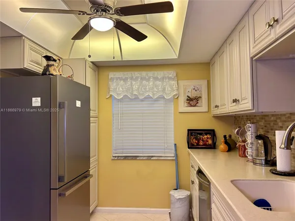 a kitchen with a sink a refrigerator and cabinets