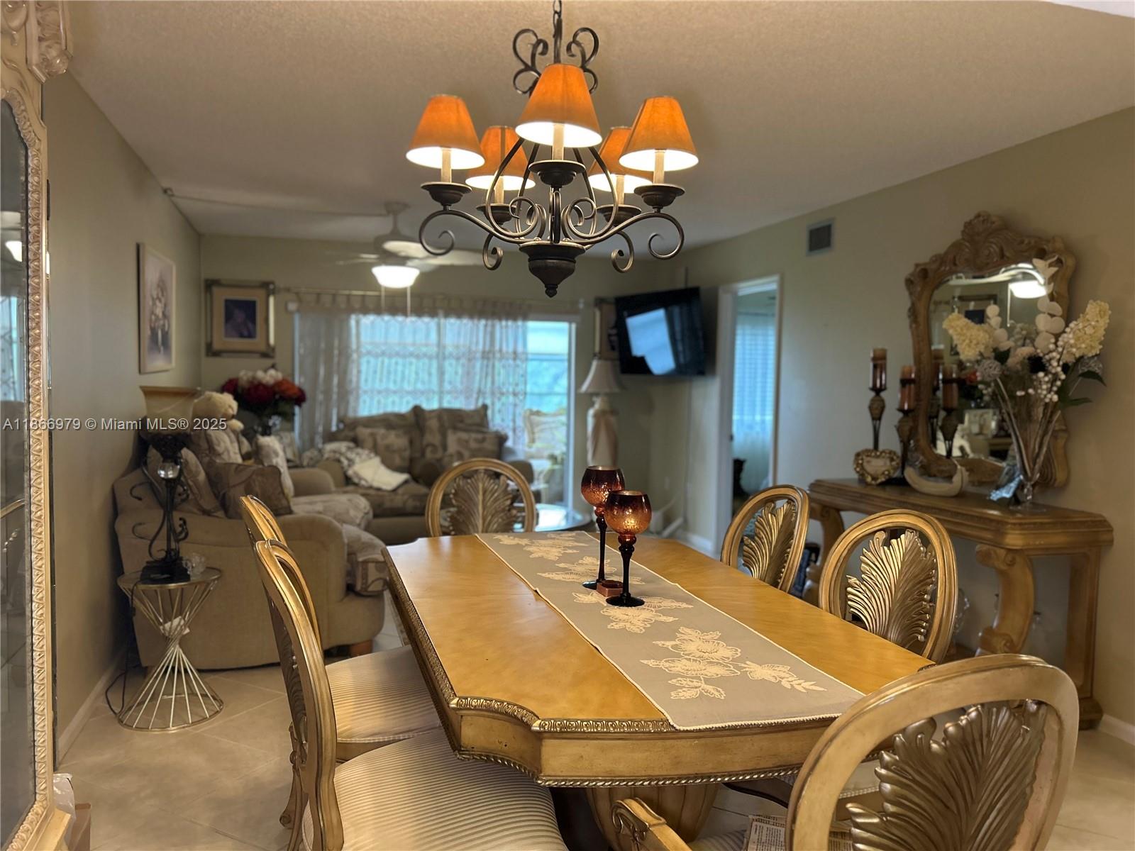 9802 Marina Boulevard, Unit 125 Boca Raton, FL 33428 - Photo 8 of 33 a view of a dining room with furniture and chandelier