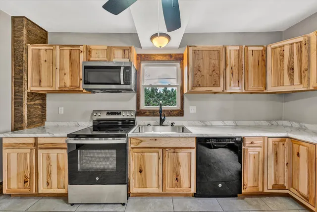 a kitchen with stainless steel appliances granite countertop a stove a sink and a microwave