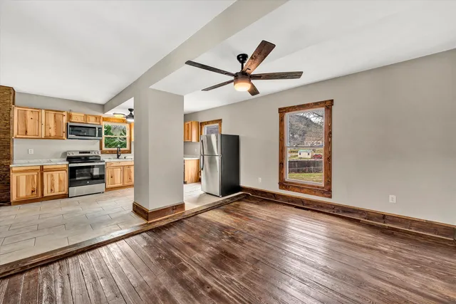 a view of a kitchen with wooden floor and a ceiling fan