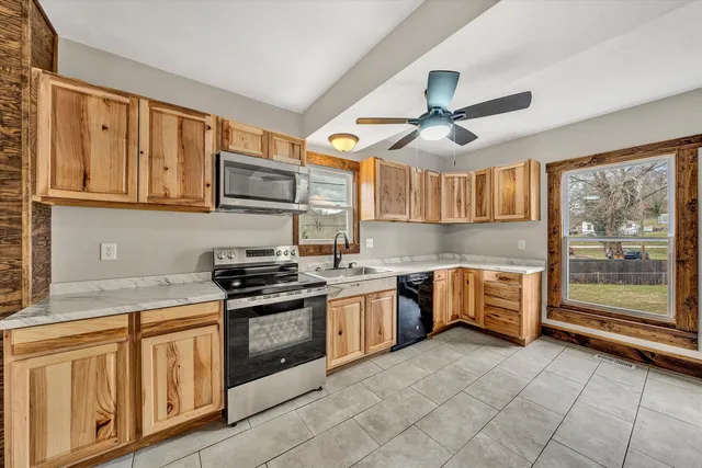 a kitchen with stainless steel appliances granite countertop a stove sink and cabinets