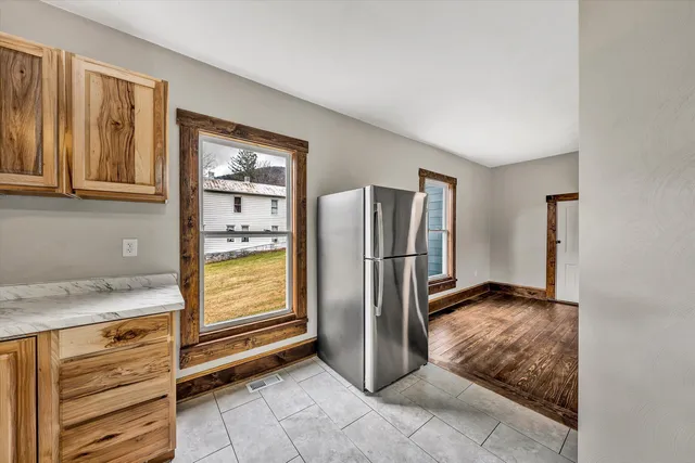 a view of kitchen with refrigerator and cabinet