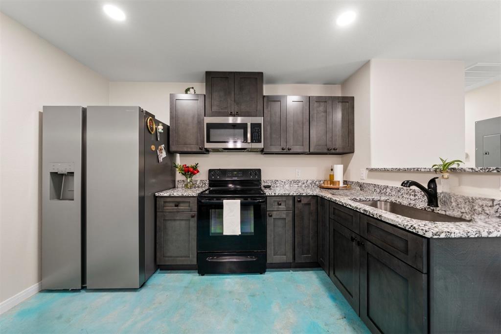 3109 North 27th Street Waco, TX 76708 - Photo 8 of 17 a kitchen with stainless steel appliances granite countertop a stove a refrigerator and a sink