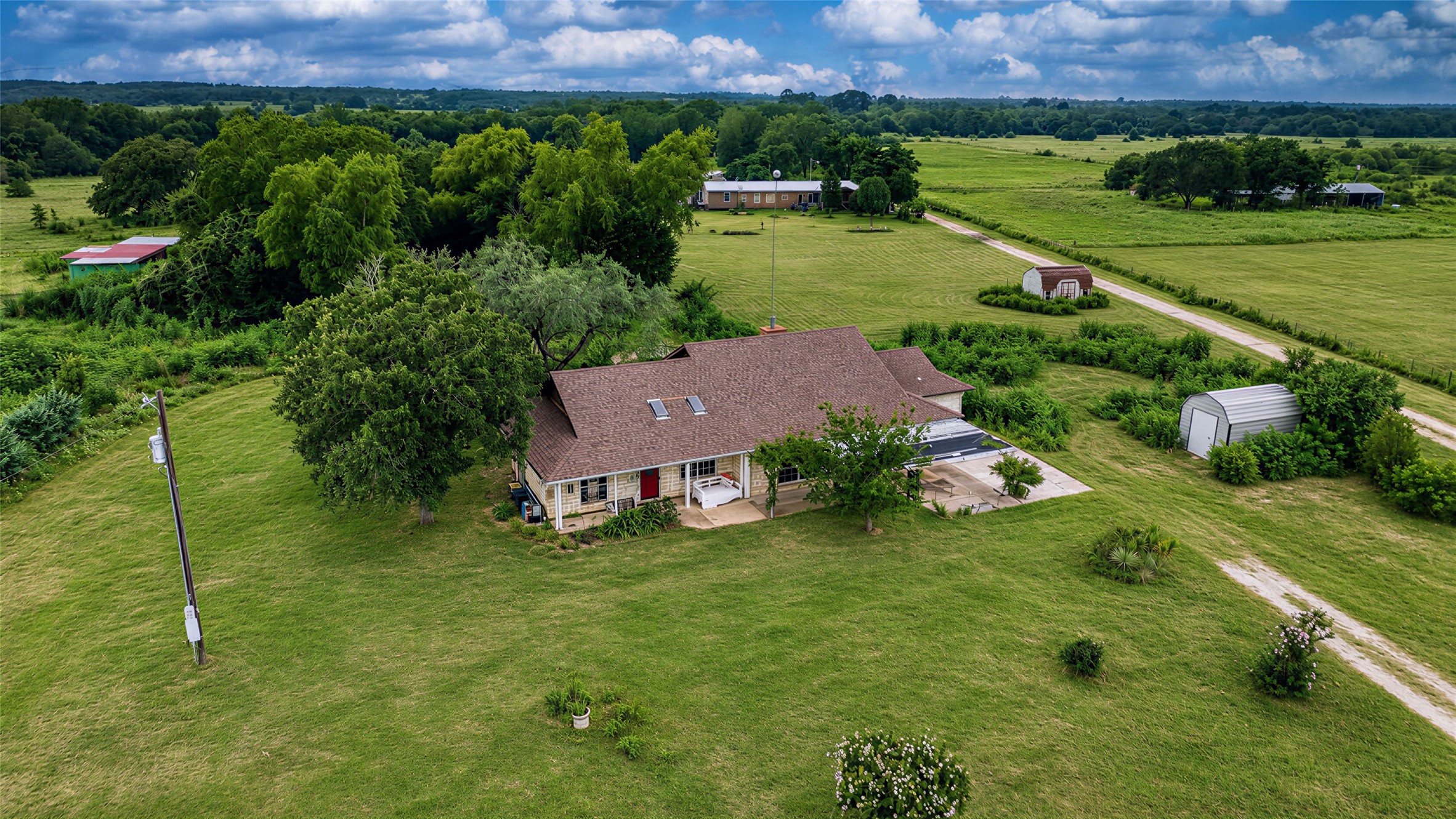 358 Easley Road Smithville, TX 78957 - Photo 34 of 36 An aerial perspective reveals a charming residence nestled amidst a verdant landscape with open fields.