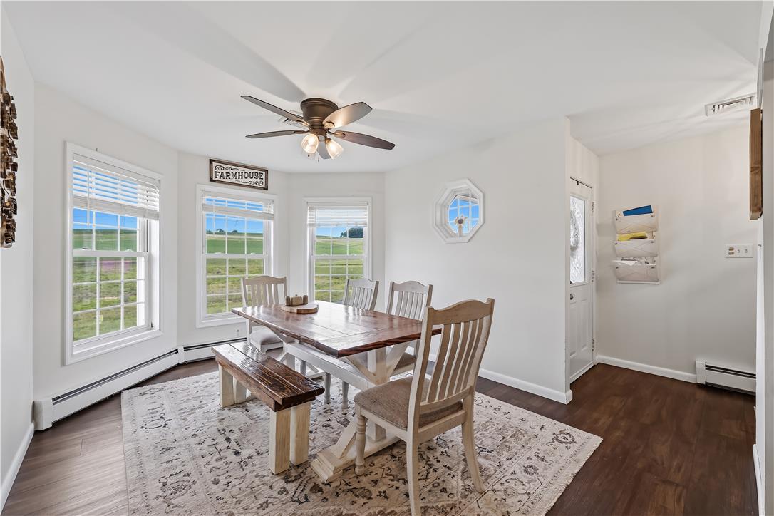 9868 Stagecoach Road Kempton, PA 19529 - Photo 5 of 17 A spacious dining area with wood flooring and large windows offers serene views of the surrounding landscape.