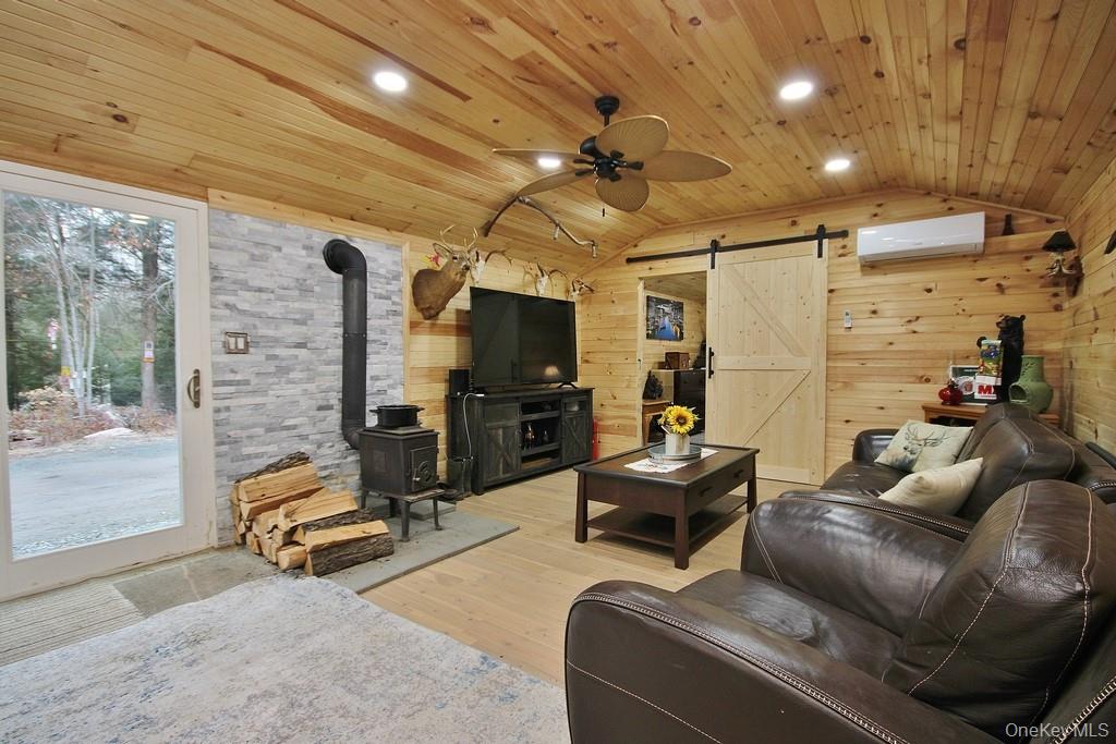 703 Dahlia Road Livingston Manor, NY 12758 - Photo 12 of 44 a living room with furniture gym equipment and a fireplace