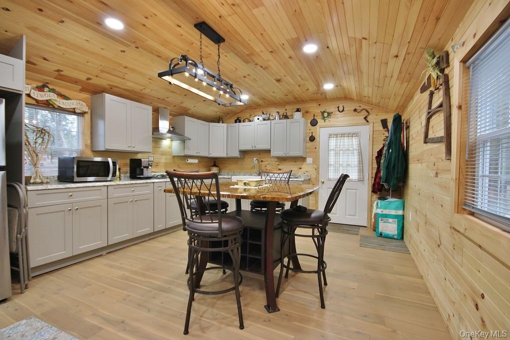 703 Dahlia Road Livingston Manor, NY 12758 - Photo 3 of 44 a kitchen with stainless steel appliances kitchen island granite countertop a table chairs sink and cabinets