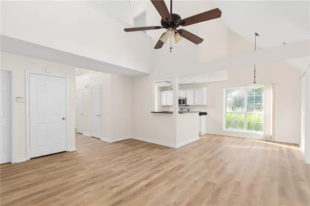 a view of a kitchen with wooden floor and a ceiling fan