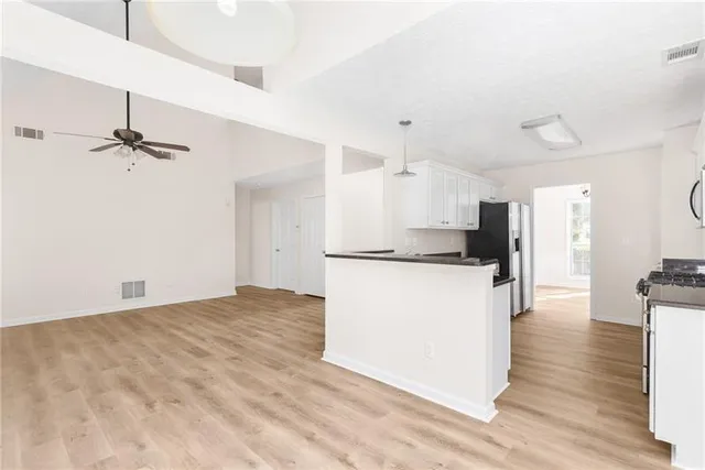 a view of kitchen with refrigerator and wooden floor